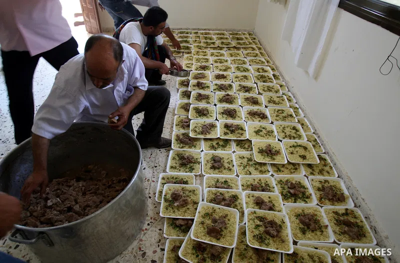 Palestinians prepare dishes of rice and meat for guests attending the wedding celebration of Alaa Sabti in the West Bank village of Salem, near Nablus , June 11, 2011. Photo by Wagdi Eshtayah
