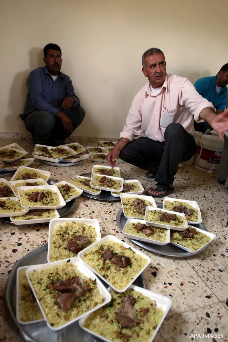 Palestinians prepare dishes of rice and meat for guests attending the wedding celebration of Alaa Sabti in the West Bank village of Salem, near Nablus , June 11, 2011. Photo by Wagdi Eshtayah