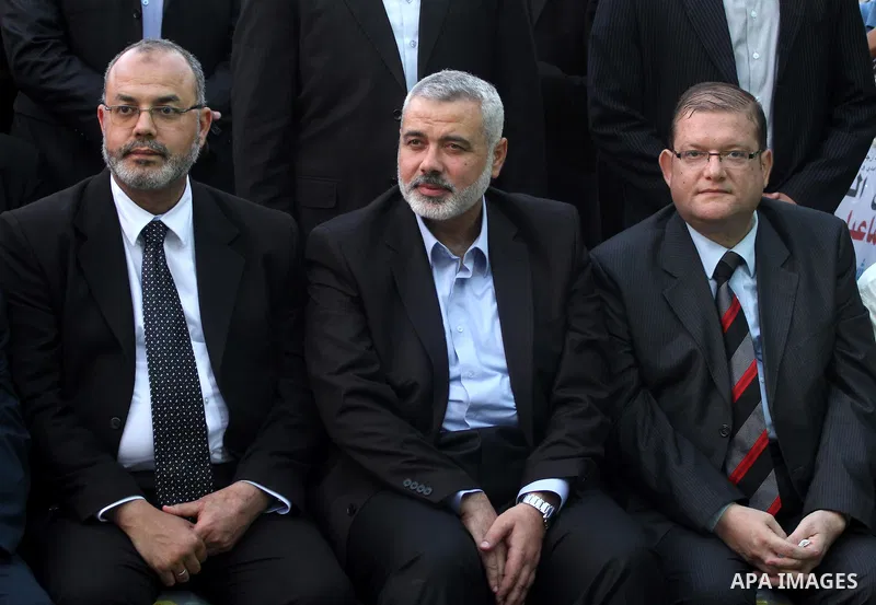 The members of the Muslim Brotherhood, Ezz El-Deen Al-Hussini and Hazem Farouk sit next to Palestinian prime minister in Gaza Strip, Ismail Hanyia during their visit to the condolences tent of Mohammed Shamaa, one of the...