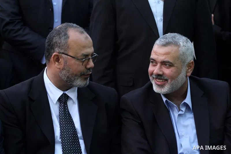 The member of the Muslim Brotherhood, Ezz El-Deen Al-Hussini speaks with Palestinian prime minister in Gaza Strip, Ismail Hanyia during their visit to the condolences tent of Mohammed Shamaa, one of the Hamas movement fo...