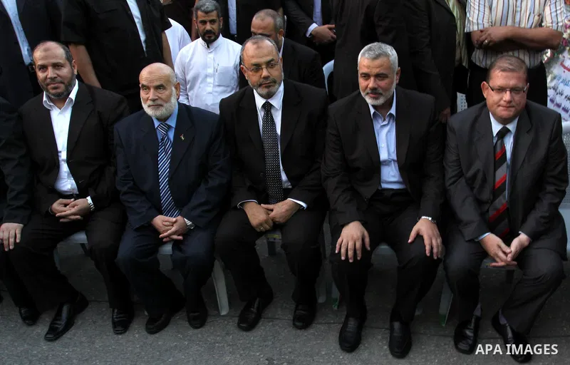 The members of the Muslim Brotherhood, Ezz El-Deen Al-Hussini and Hazem Farouk sit next to Palestinian prime minister in Gaza Strip, Ismail Hanyia during their visit to the condolences tent of Mohammed Shamaa, one of the...