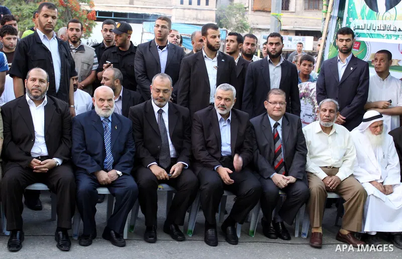 The members of the Muslim Brotherhood, Ezz El-Deen Al-Hussini and Hazem Farouk sit next to Palestinian prime minister in Gaza Strip, Ismail Hanyia during their visit to the condolences tent of Mohammed Shamaa, one of the...