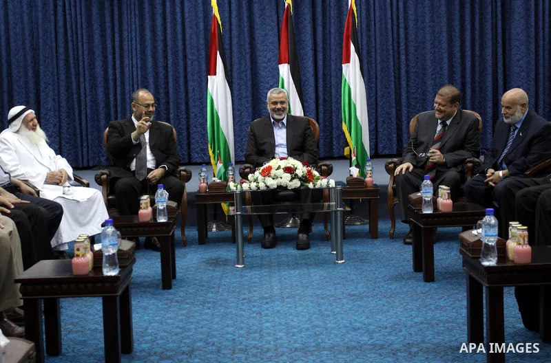 The members of the Muslim Brotherhood, Ezz El-Deen Al-Hussini and Hazem Farouk sit next to Palestinian prime minister in Gaza Strip, Ismail Hanyia at his office in Gaza city on June 12,2011 during the visiting of Muslim...