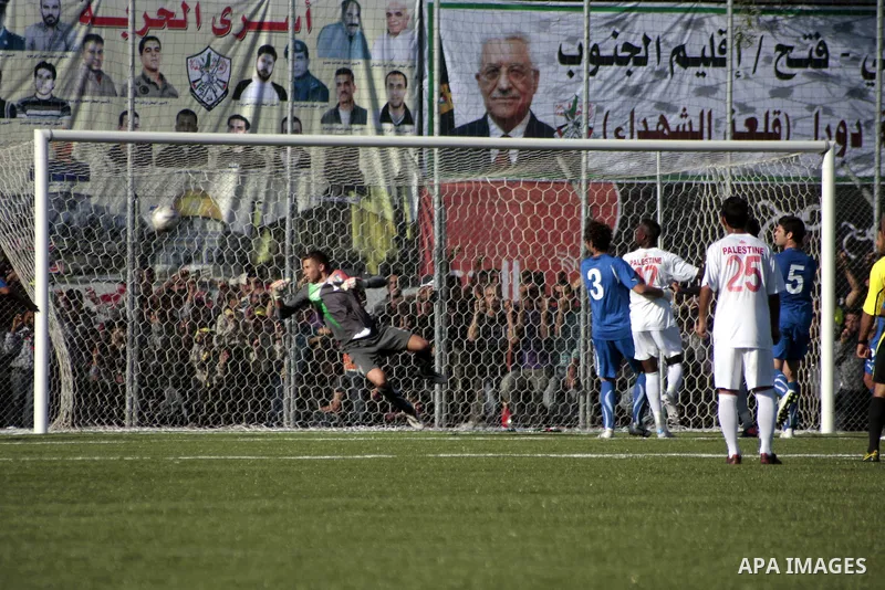 Palestinian players celebrate after a goal during a friendly football match between the Palestinian and Italian Olympic teams to mark the inauguration of the Dura Stadium near the West Bank city of Hebron on June 12, 201...