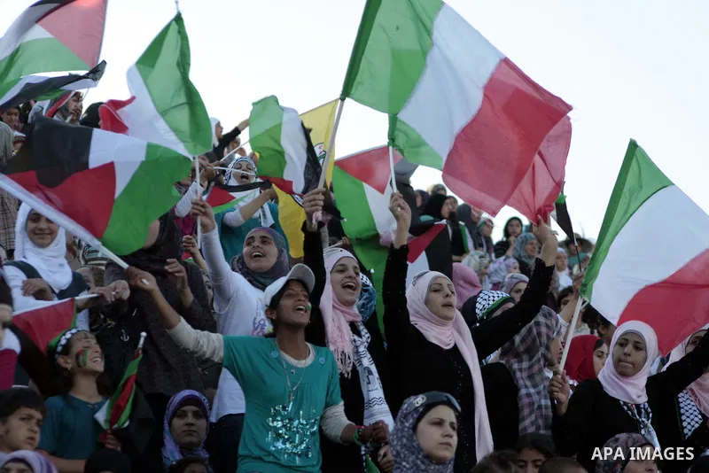 Palestinian fans cheer for their team during a friendly football match between the Palestinian and Italian Olympic teams to mark the inauguration of the Dura Stadium near the West Bank city of Hebron on June 12, 2011. Ph...