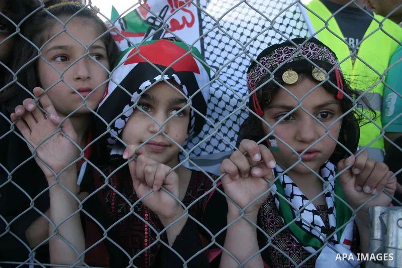 Palestinian fans cheer for their team during a friendly football match between the Palestinian and Italian Olympic teams to mark the inauguration of the Dura Stadium near the West Bank city of Hebron on June 12, 2011. Ph...