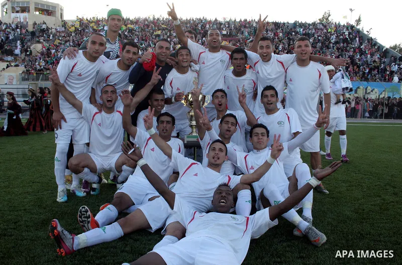 Palestinian players celebrate after the winning during a friendly football match between the Palestinian and Italian Olympic teams to mark the inauguration of the Dura Stadium near the West Bank city of Hebron on June 12...
