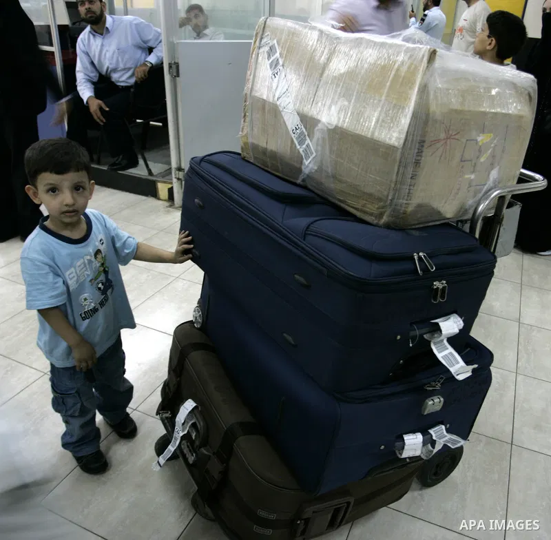A Palestinian boy with his family during loading their luggage coming from Egypt through the Rafah border crossing in the southern Gaza Strip on on June 13, 2011. Photo by Abed Rahim Khatib