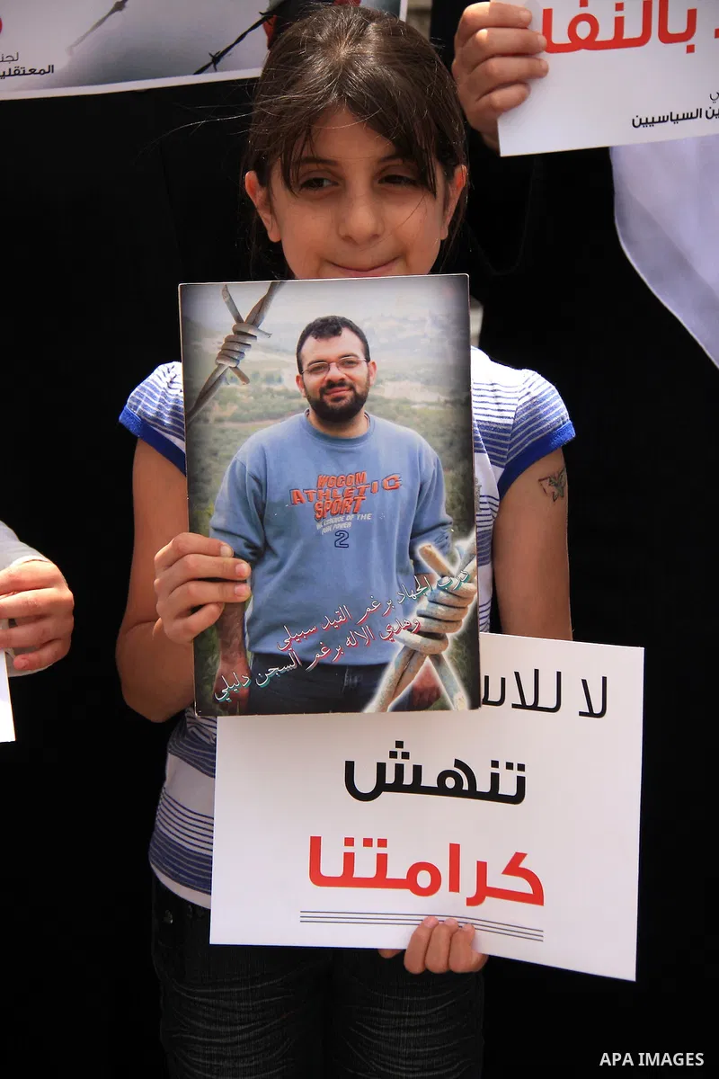 Palestinian Hamas supporters hold banners of relatives who were arrested and imprisoned for political reasons by Palestinian Authority security forces, during a protest in the West Bank city ofof Nablus on June 13, 2011....