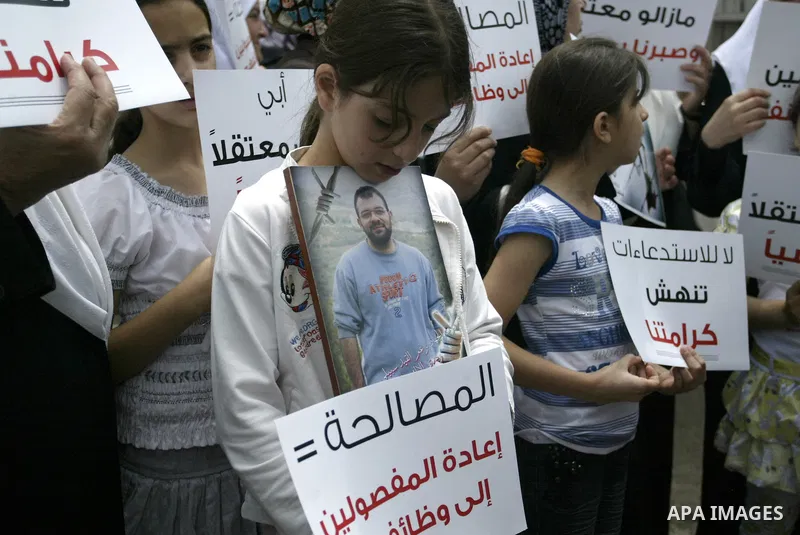 Palestinian Hamas supporters hold banners of relatives who were arrested and imprisoned for political reasons by Palestinian Authority security forces, during a protest in the West Bank city ofof Nablus on June 13, 2011....