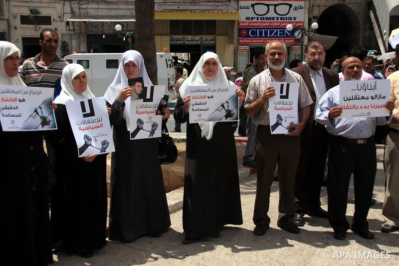 Palestinian Hamas supporters hold banners of relatives who were arrested and imprisoned for political reasons by Palestinian Authority security forces, during a protest in the West Bank city ofof Nablus on June 13, 2011....