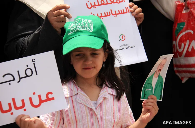 Palestinian Hamas supporters hold banners of relatives who were arrested and imprisoned for political reasons by Palestinian Authority security forces, during a protest in the West Bank city ofof Nablus on June 13, 2011....