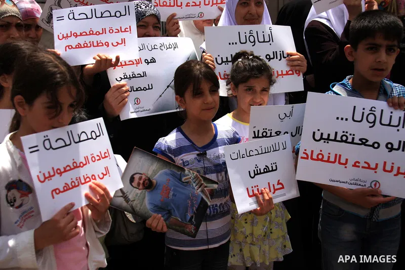 Palestinian Hamas supporters hold banners of relatives who were arrested and imprisoned for political reasons by Palestinian Authority security forces, during a protest in the West Bank city ofof Nablus on June 13, 2011....
