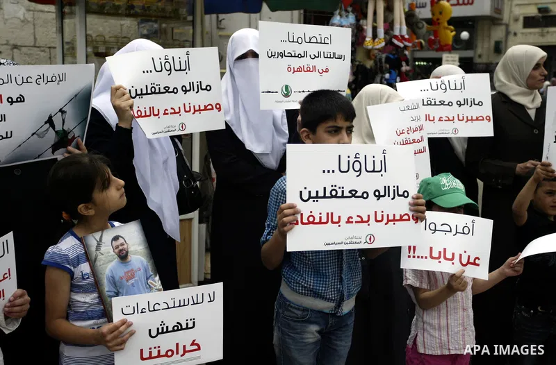 Palestinian Hamas supporters hold banners of relatives who were arrested and imprisoned for political reasons by Palestinian Authority security forces, during a protest in the West Bank city ofof Nablus on June 13, 2011....