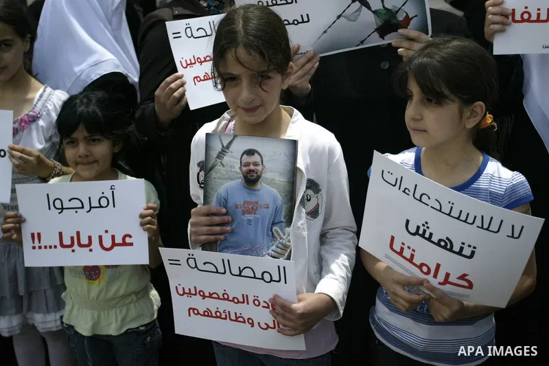 Palestinian Hamas supporters hold banners of relatives who were arrested and imprisoned for political reasons by Palestinian Authority security forces, during a protest in the West Bank city ofof Nablus on June 13, 2011....