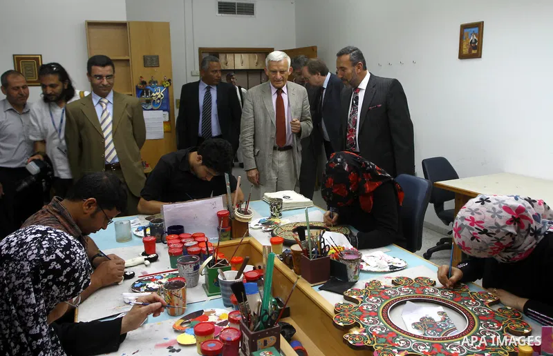 European Parliament President Jerzy Buzek speaks to a Palestinian atrists during his visit to Deaf Center in Gaza City on June 13, 2011. Photo/Ashraf Amra- POOL