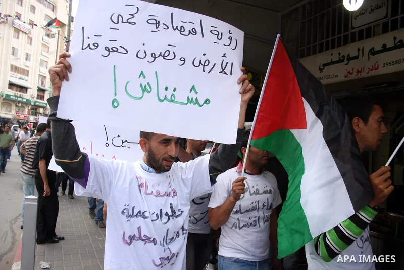 Palestinians hold national flags and banners calling for the release of prisoners for political reasons by the Palestinian security forces during a protest in the West Bank city of Ramallah, on June 13,2011. Photo by Iss...