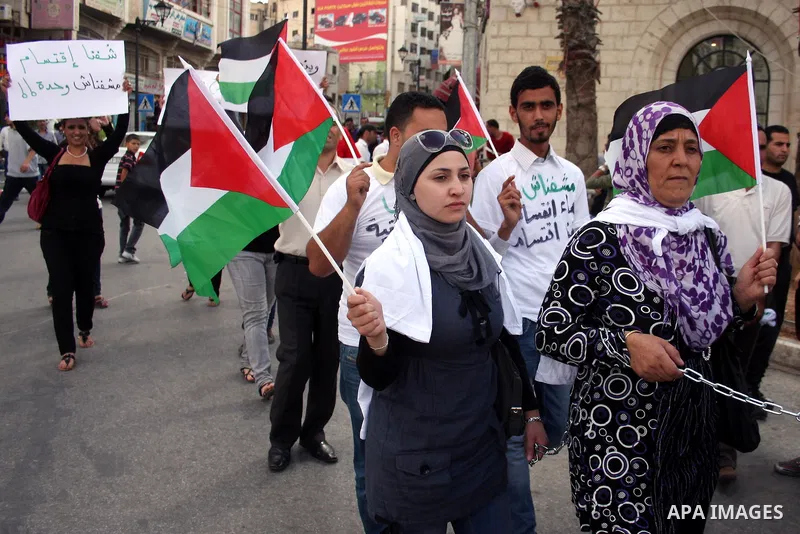Palestinians hold national flags and banners calling for the release of prisoners for political reasons by the Palestinian security forces during a protest in the West Bank city of Ramallah, on June 13,2011. Photo by Iss...