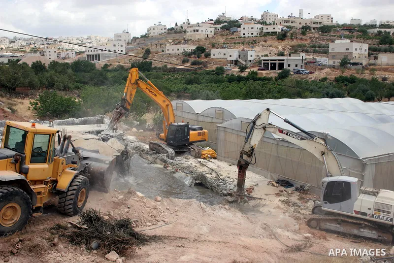 Israeli army machinery destroy a water reservoir used by Palestinian farmers in Hebron, in the Israeli-occupied West Bank, on June 14,2011. Photo by Najeh Hahlamoun.