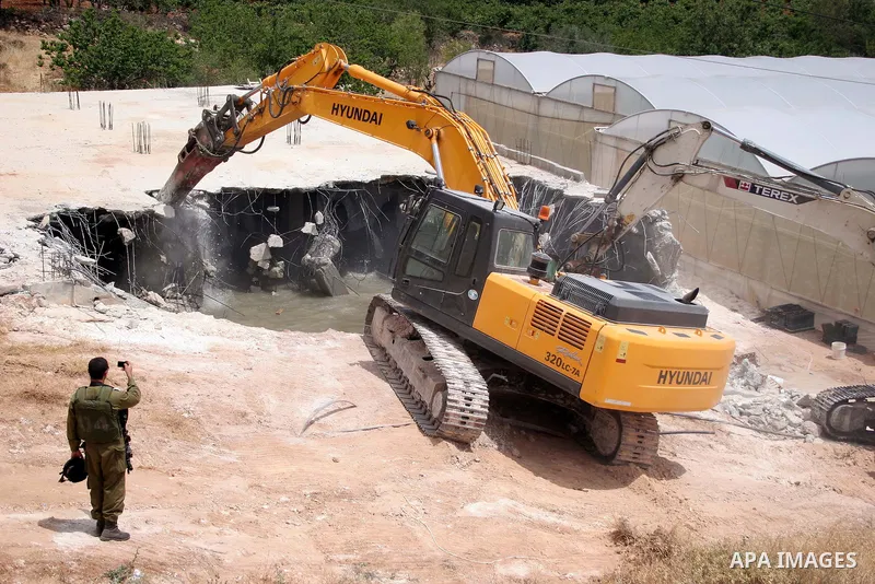 Israeli army machinery destroy a water reservoir used by Palestinian farmers in Hebron, in the Israeli-occupied West Bank, on June 14,2011. Photo by Najeh Hahlamoun.