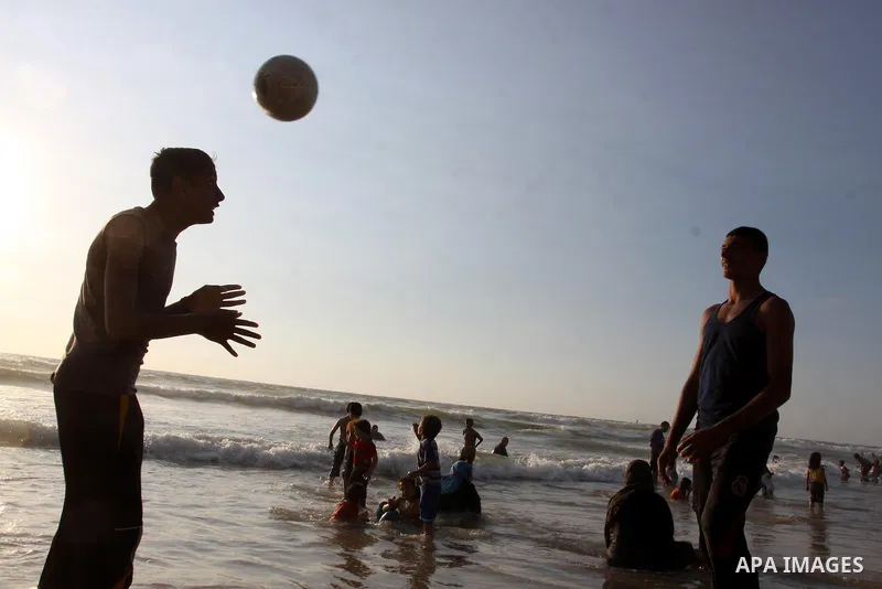 Palestinian youths enjoy swimming and playing football at the beach in Gaza city on June 14, 2011. Photo by Mohammed Asad
