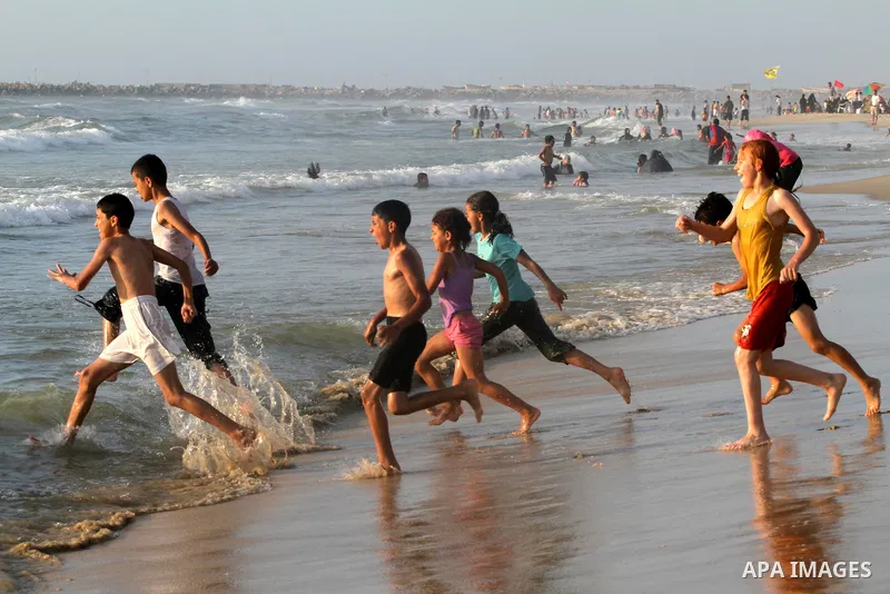 Palestinian children enjoy swimming at the beach in Gaza city on June 14, 2011. Photo by Mohammed Asad