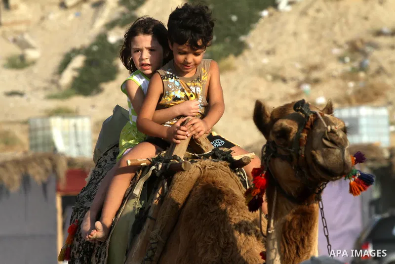 Palestinian children enjoy swimming and riding camels at the beach in Gaza city on June 15, 2011. Photo by Mohammed Asad