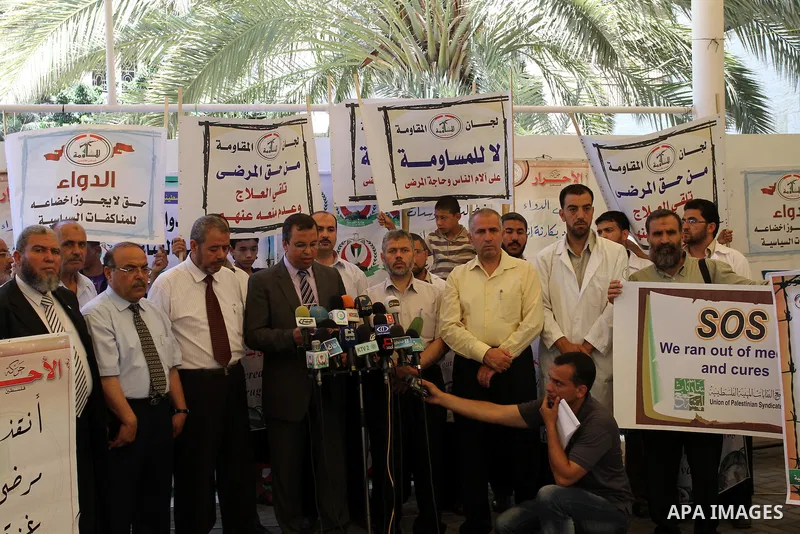 Palestinian doctors display a speech in a press conference during a protest in the headquarters of the Red Cross calling for lifting the siege and the introduction of medicines in Gaza city on June 15, 2011. Photo by Moh...