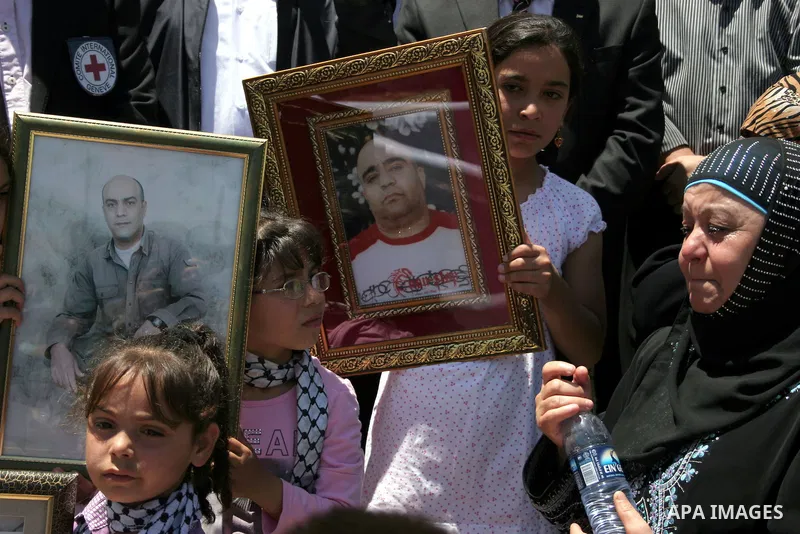Palestinians hold pictures of their jailed relatives during a protest calling for the release of prisoners from Israeli jails, outside the Red Cross offices in the West Bank city of Hebron on June 15, 2011. Photo by Naje...