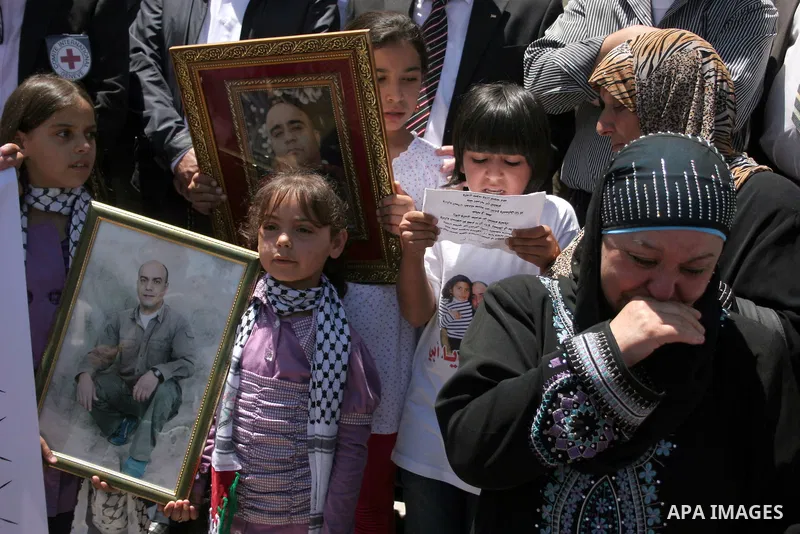 Palestinians hold pictures of their jailed relatives during a protest calling for the release of prisoners from Israeli jails, outside the Red Cross offices in the West Bank city of Hebron on June 15, 2011. Photo by Naje...