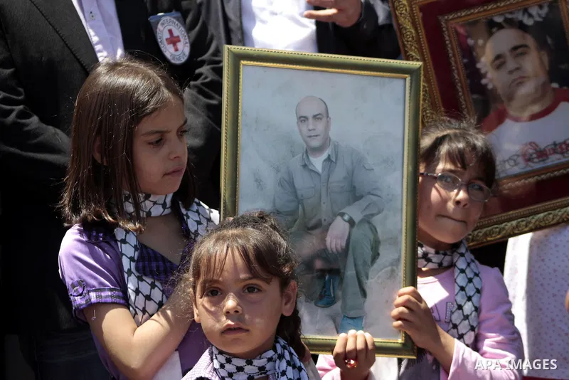 Palestinians hold pictures of their jailed relatives during a protest calling for the release of prisoners from Israeli jails, outside the Red Cross offices in the West Bank city of Hebron on June 15, 2011. Photo by Naje...