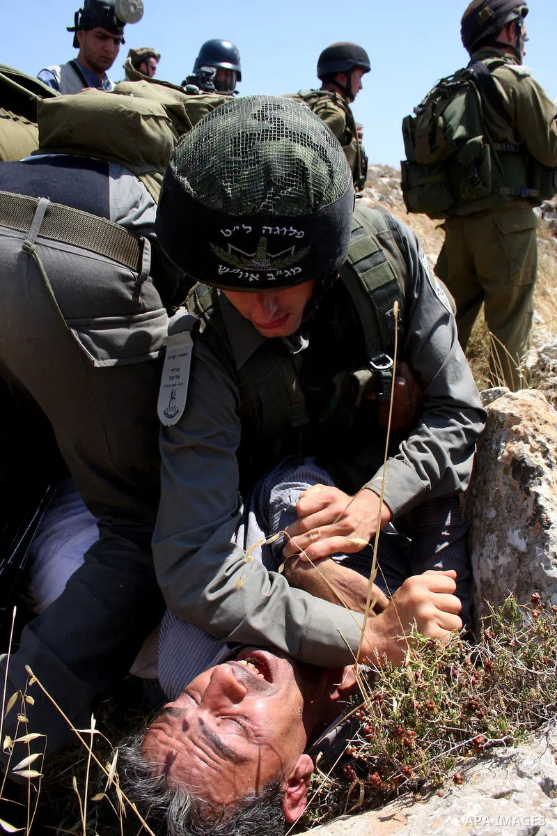 Israeli soldiers arrest a Palestinian protestor as residents from the village of Deir Qadis near Ramallah tried to prevent Israeli bulldozers from progressing towards their land during a demonstration against the expansi...