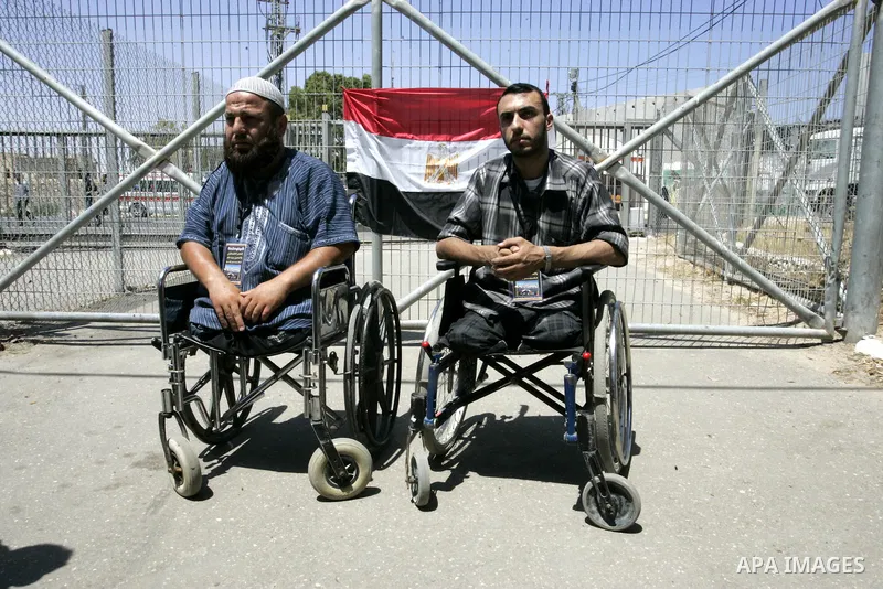 Palestinians holds the Egyptian flags during a rally in front of the Rafah border crossing in the southern Gaza Strip on June 16, 2011, demanding it to be open permanently and without restrictions or conditions on the pa...
