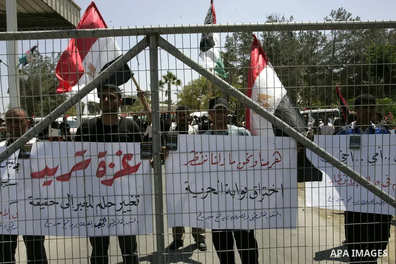 Palestinians hold their national flags and the Egyptian flags and banners during a rally in front of the Rafah border crossing in the southern Gaza Strip on June 16, 2011, demanding it to be open permanently and without...