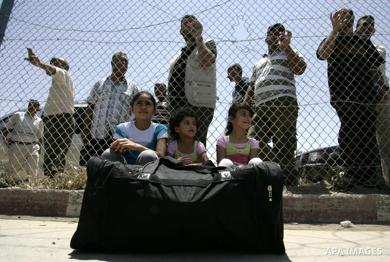 Palestinians wait at the gates of the Rafah border crossing during a rally in the southern Gaza Strip on June 16, 2011, demanding it to be open permanently and without restrictions or conditions on the passengers. Photo...