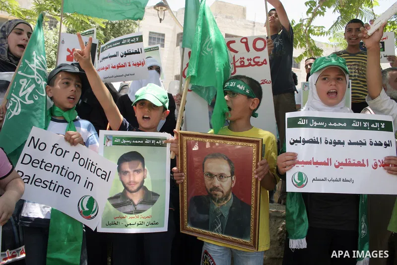 Palestinian Hamas supporters hold up pictures of relatives who were arrested and imprisoned for political reasons by Palestinian Authority security forces, during a protest in the West Bank city of Hebron, on June 16,201...