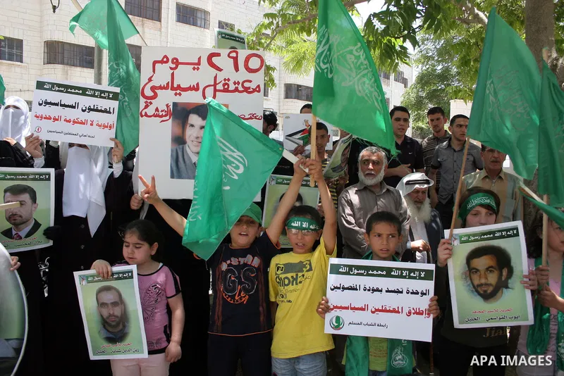 Palestinian Hamas supporters hold up pictures of relatives who were arrested and imprisoned for political reasons by Palestinian Authority security forces, during a protest in the West Bank city of Hebron, on June 16,201...