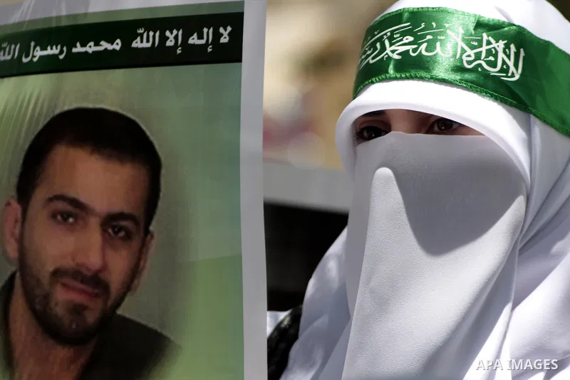 Palestinian Hamas supporters hold up pictures of relatives who were arrested and imprisoned for political reasons by Palestinian Authority security forces, during a protest in the West Bank city of Hebron, on June 16,201...