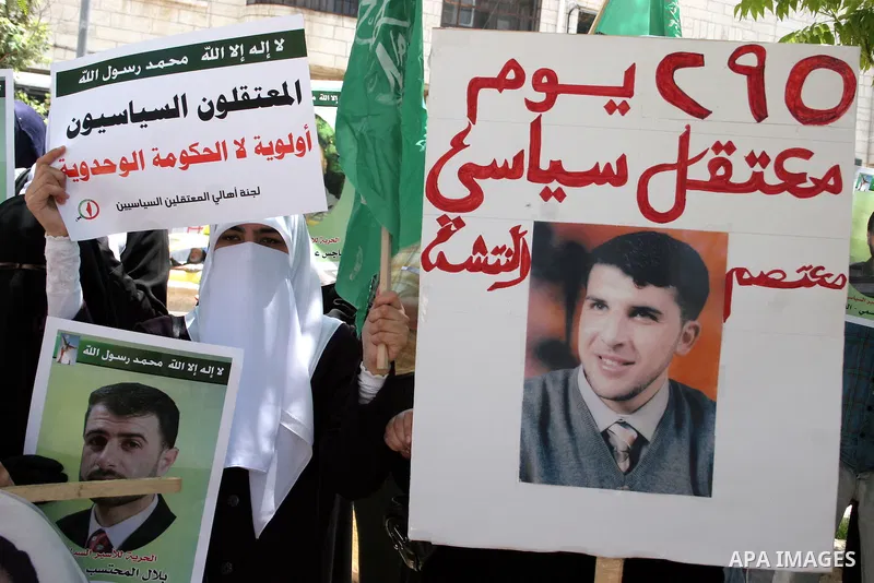 Palestinian Hamas supporters hold up pictures of relatives who were arrested and imprisoned for political reasons by Palestinian Authority security forces, during a protest in the West Bank city of Hebron, on June 16,201...