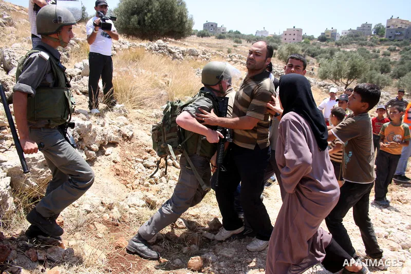 Israeli border guards hold back Palestinian protestors as residents from the village of Deir Qadis near Ramallah hold a demonstration against the expansion of nearby settlements on June 16, 2011, in the Israeli-occupied...