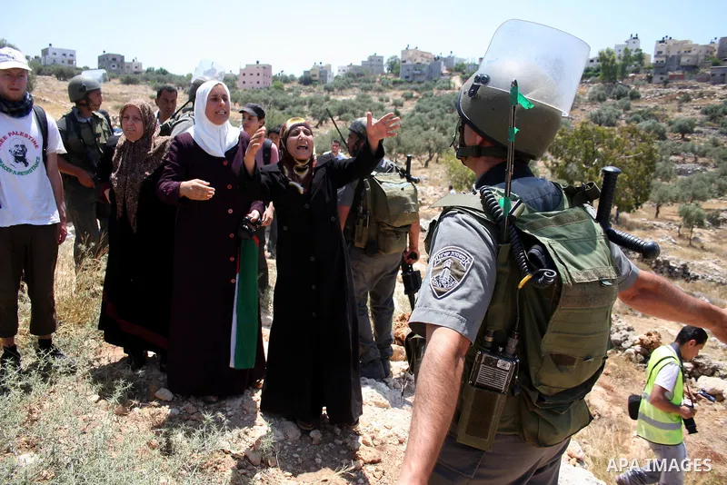 Israeli border guards hold back Palestinian protestors as residents from the village of Deir Qadis near Ramallah hold a demonstration against the expansion of nearby settlements on June 16, 2011, in the Israeli-occupied...