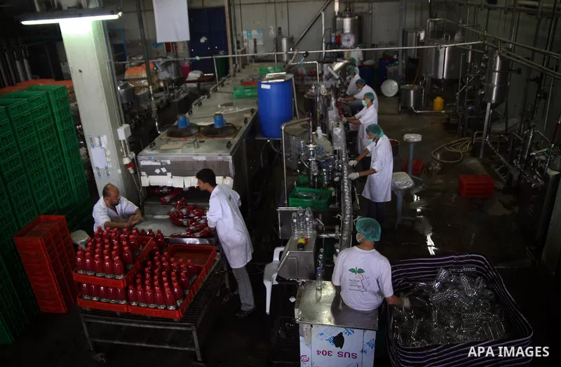 Palestinian workers bottle fruit juice at Juice Factory in Gaza City on Jun 16, 2011. it depends on citrus and fruit that are widely planted in Gaza Strip. Due to the closure of Gaza Strip crossings and the Israeli banni...