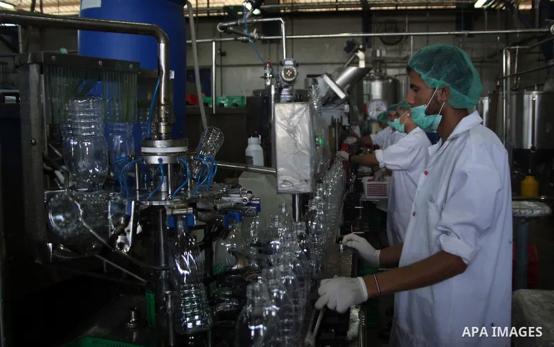 Palestinian workers bottle fruit juice at Juice Factory in Gaza City on Jun 16, 2011. it depends on citrus and fruit that are widely planted in Gaza Strip. Due to the closure of Gaza Strip crossings and the Israeli banni...