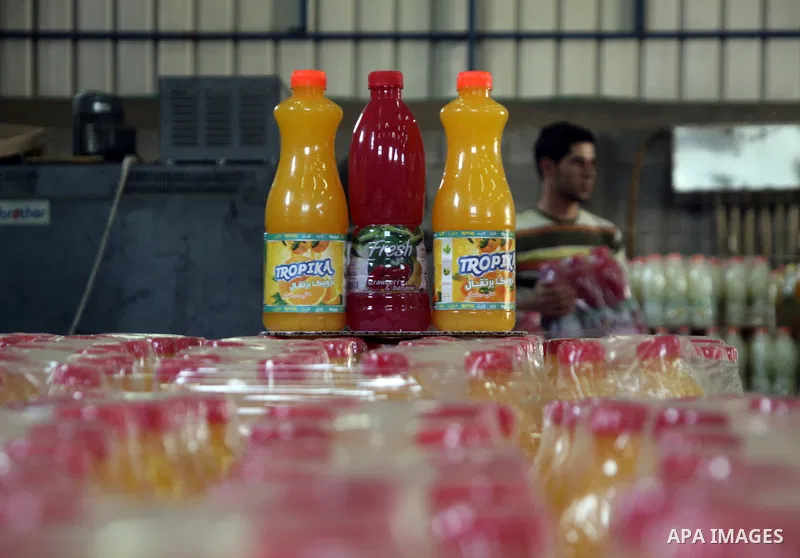 Palestinian workers bottle fruit juice at Juice Factory in Gaza City on Jun 16, 2011. it depends on citrus and fruit that are widely planted in Gaza Strip. Due to the closure of Gaza Strip crossings and the Israeli banni...