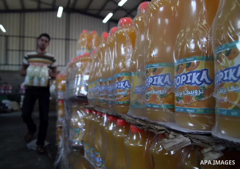 Palestinian workers bottle fruit juice at Juice Factory in Gaza City on Jun 16, 2011. it depends on citrus and fruit that are widely planted in Gaza Strip. Due to the closure of Gaza Strip crossings and the Israeli banni...