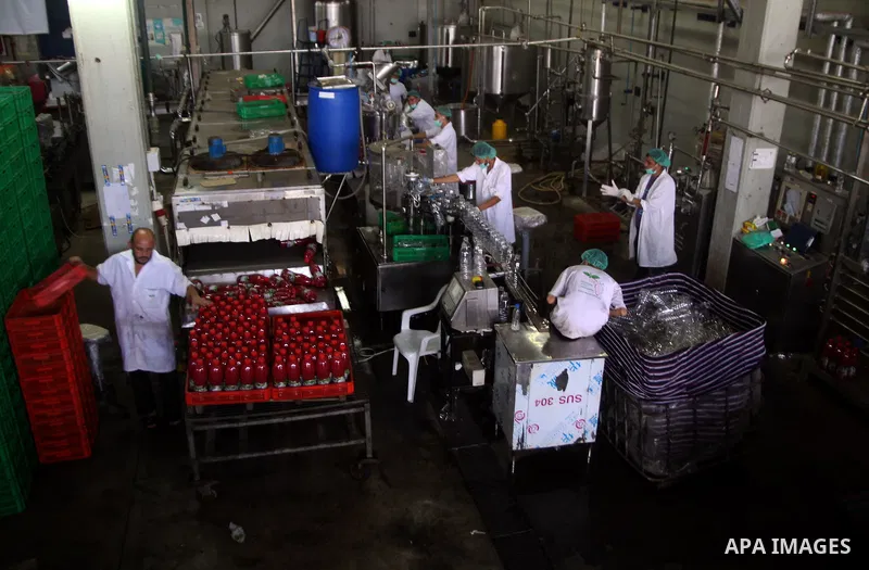 Palestinian workers bottle fruit juice at Juice Factory in Gaza City on Jun 16, 2011. it depends on citrus and fruit that are widely planted in Gaza Strip. Due to the closure of Gaza Strip crossings and the Israeli banni...