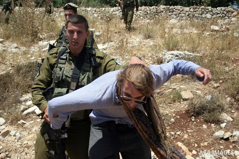 Israeli soldiers detain a foreign activist on Jun 18,2011 during a protest by foreign, Israeli and Palestinian activists against the Jewish settlement of Karmei Tzur near the Palestinian village of Beit Omar, just north...