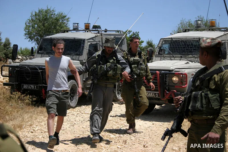 Israeli soldiers detain a foreign activist on Jun 18,2011 during a protest by foreign, Israeli and Palestinian activists against the Jewish settlement of Karmei Tzur near the Palestinian village of Beit Omar, just north...