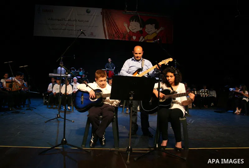 Blind Palestinian children sing and play on the musical instruments during a ceremony in the West Bank city of Ramallah on Jun 18,2011. Photo by Issam Rimawi