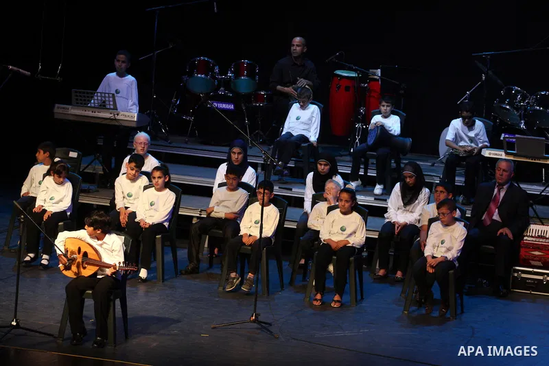 Blind Palestinian children sing and play on the musical instruments during a ceremony in the West Bank city of Ramallah on Jun 18,2011. Photo by Issam Rimawi